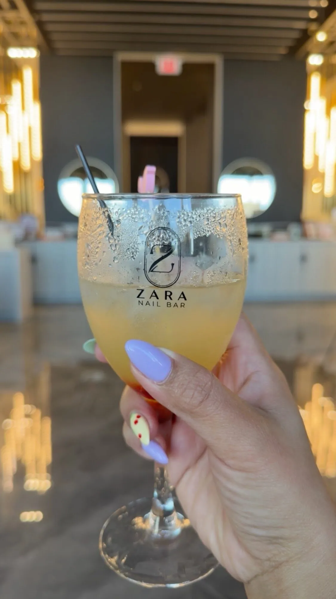 A guest holding a mimosa in a Zara Nail Bar glass at the Hudson salon.