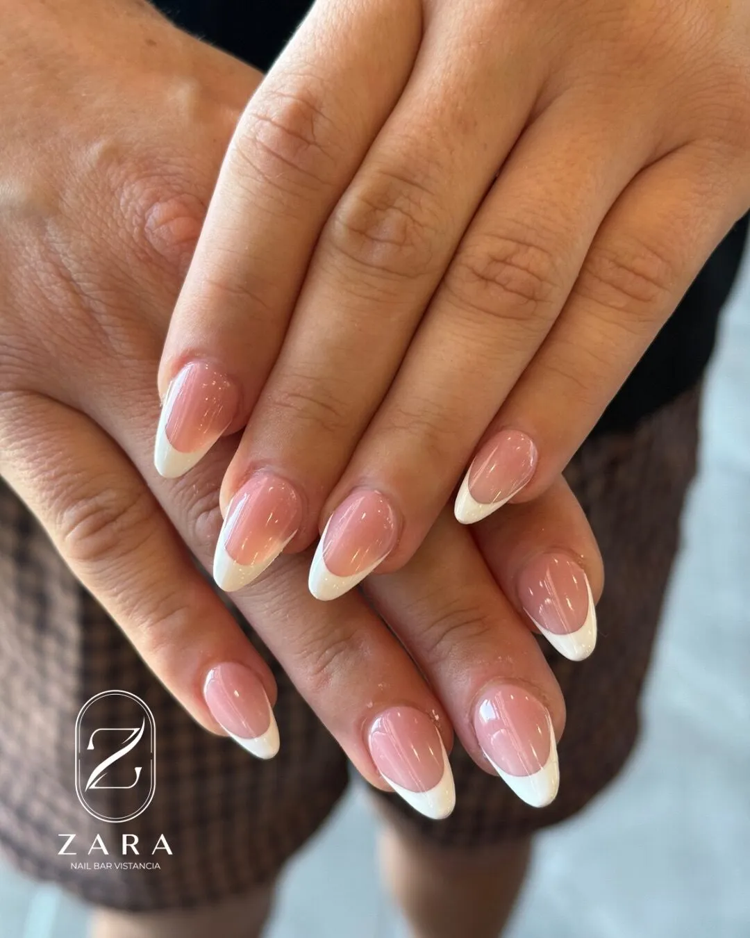 Medium almond nails in a soft pink with a classic white French tip.