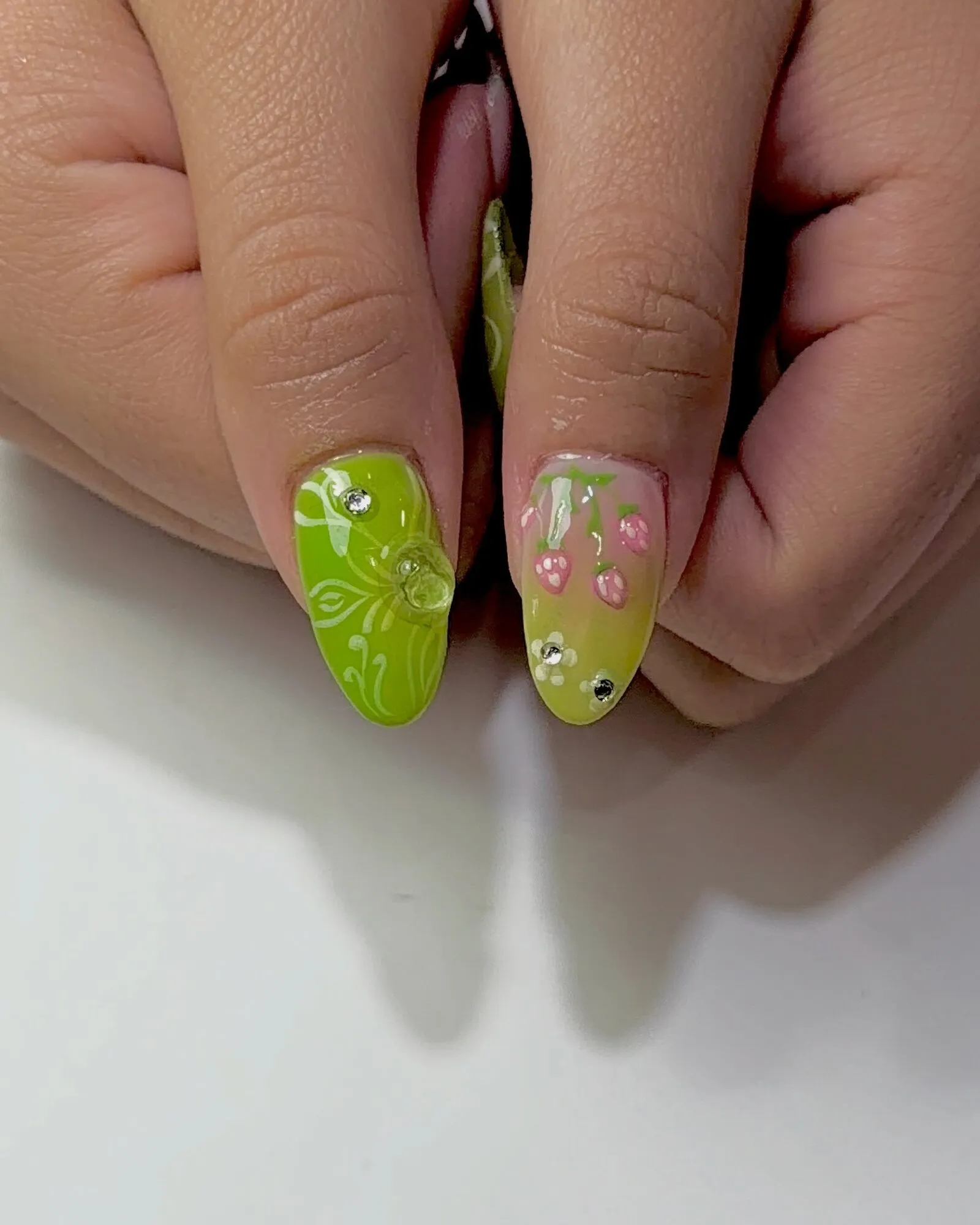 Almond nails in lime green with hand-painted white florals, tiny pink tulips and crystals.