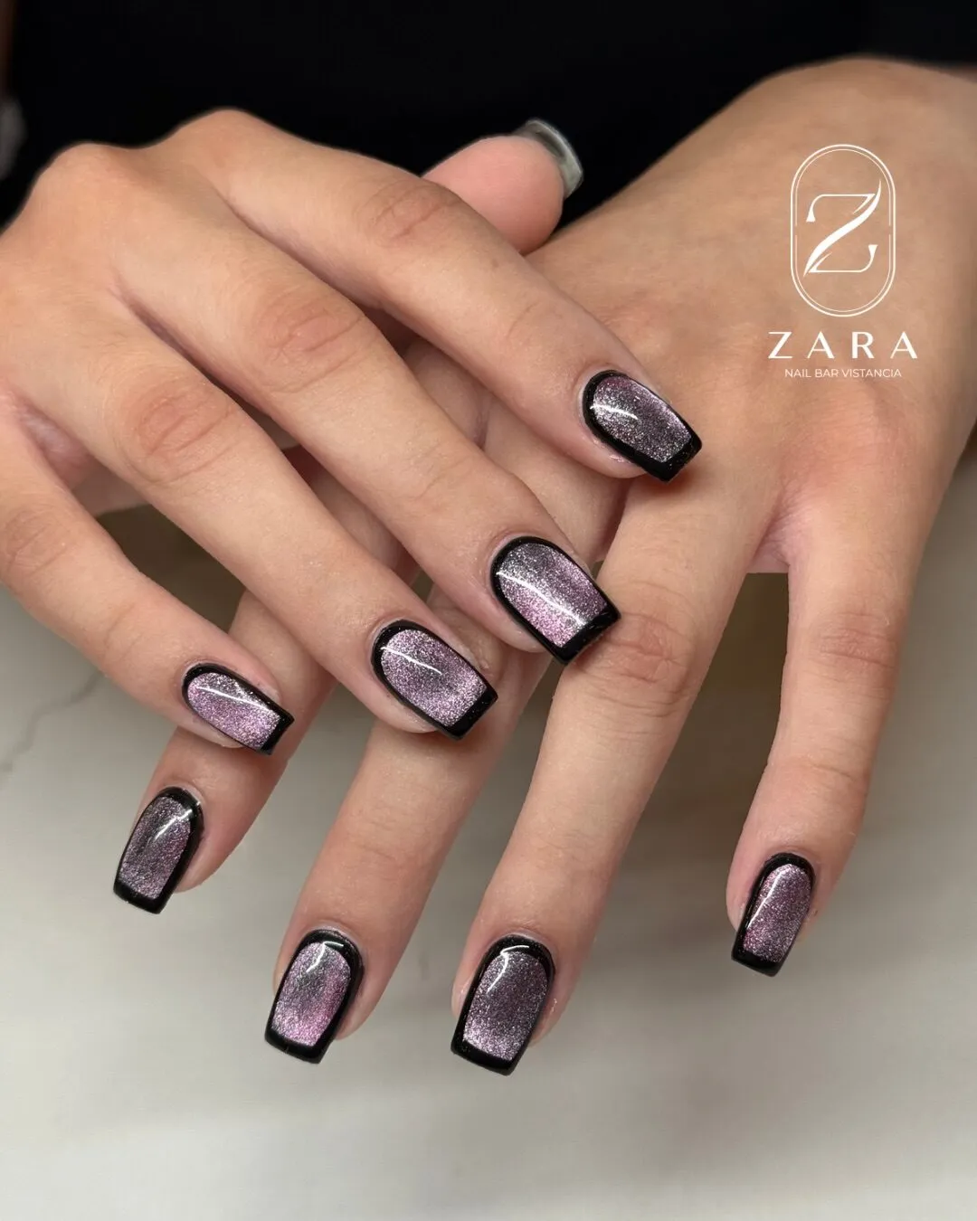 Short square cat-eye nails in a shimmering mauve, each outlined in black.